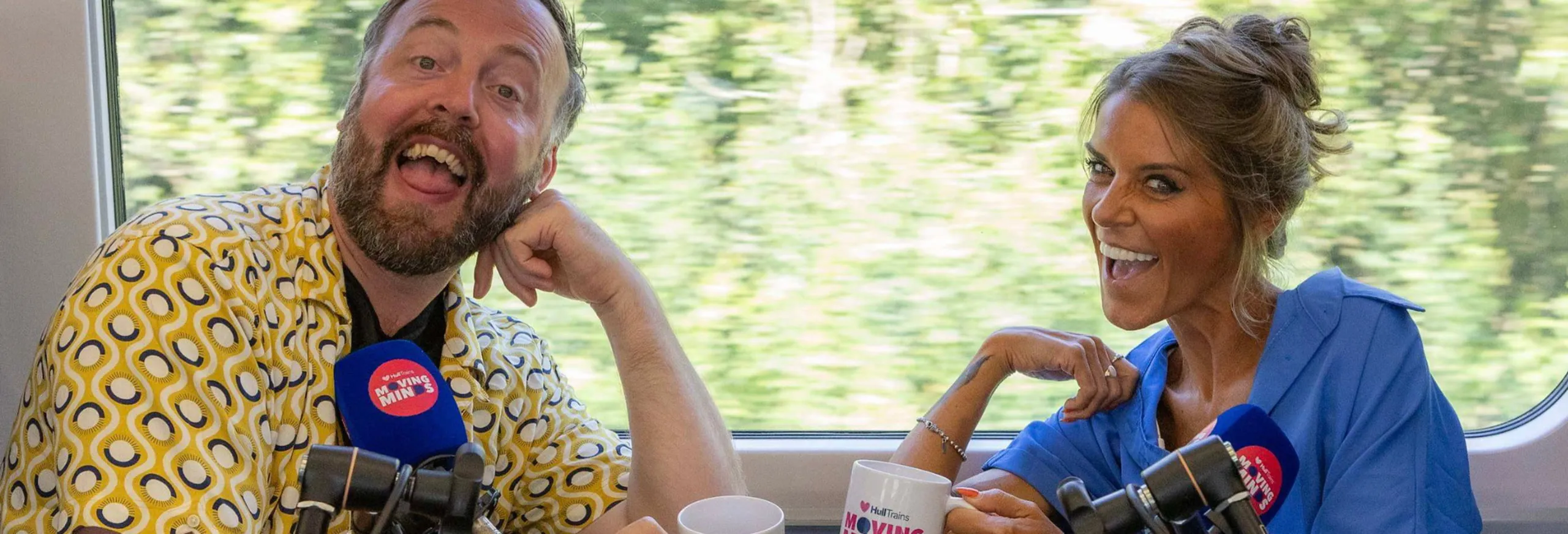 Two people smiling for a photo on the Moving Minds podcast onboard a Hull Trains service
