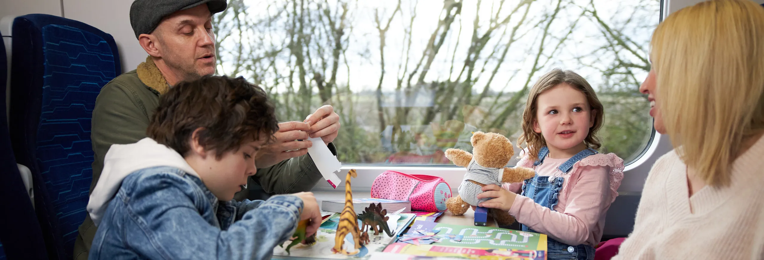 family sat around table on board train