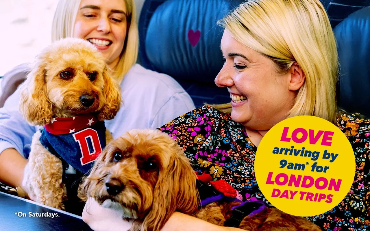 Two women and two dogs onboard a Hull Trains service. Text reads Love arriving by 9am for London day trips.