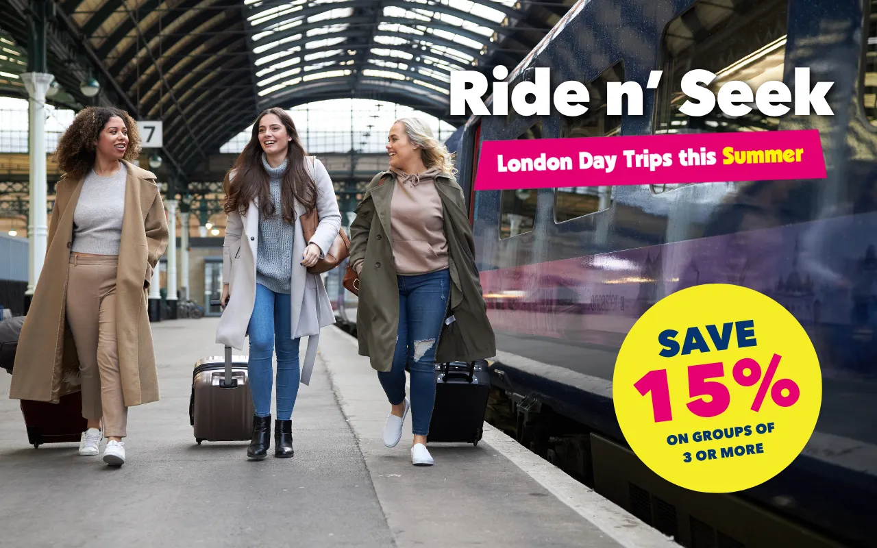 A photo of 3 people walking on a train platform with suitcases