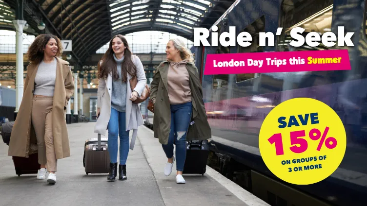 A photo of 3 people walking on a train platform with suitcases