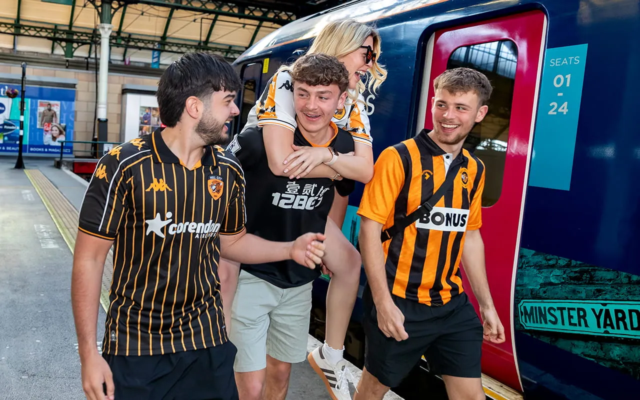 A group of Hull City supporters walking on the platform